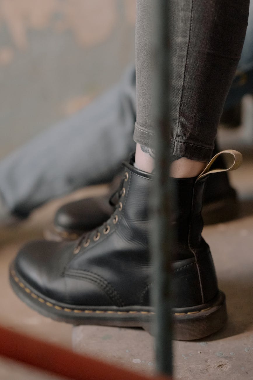 person wearing black leather dr martens boots