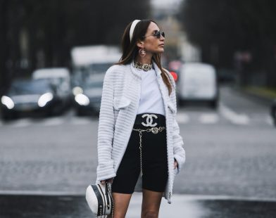 Woman wears Chanel tweed jacket, white t-shirt and shorts at fashion week